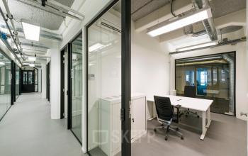 Modern office space in Amsterdam Houthavens, featuring sleek furnishings and glass partitions, ideal for office space rental.