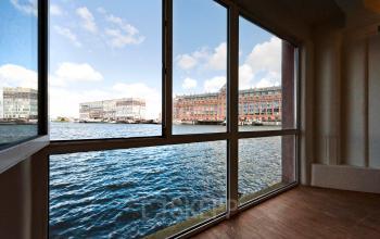 Bright office space with large windows overlooking the Amsterdam Houthavens waterfront, ideal for office space rental.