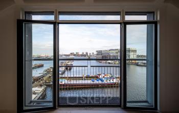 View from an office at Van Diemenstraat 20-200 in Amsterdam Houthavens, overlooking the harbor and ships. Ideal for those seeking an office space rental with stunning vistas.