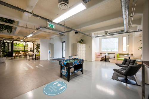 Spacious office interior in Amsterdam Houthavens featuring a foosball table, seating areas, and meeting space available for office space rental.