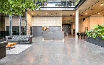 Spacious lobby with modern design at Moermanskkade 109-113, highlighting a reception area, greenery, and seating, perfect for your office space rental needs in Amsterdam Houthavens.
