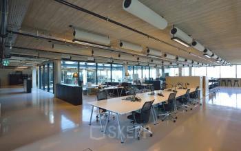 Spacious open floor plan in an office to rent at Moermanskkade 109-113, Amsterdam Houthavens, featuring modern desks, chairs, and ample natural light.