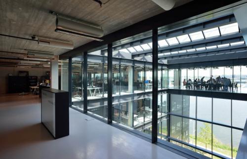 Modern office interior at Moermanskkade 109-113, Amsterdam Houthavens, featuring a spacious open floor plan with large windows and natural light. Ideal for office space rental.