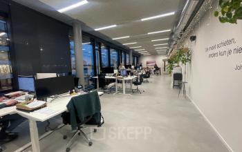 Modern office space at Moermanskkade 303, Amsterdam Houthavens, featuring open-plan workspaces with desks, computers, and employees working collaboratively.