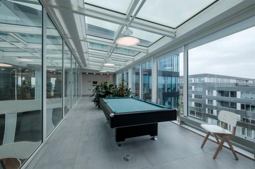 Bright office space with a pool table under a glass ceiling at Pedro de Medinalaan 7, Amsterdam IJburg, available for office space rental.