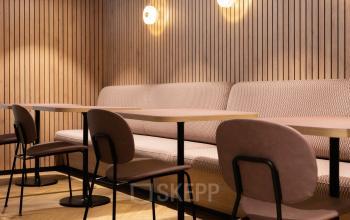 Cozy corner for casual meetings with wooden wall panels and comfortable seating at office space rental in Amsterdam Nieuw-West, Overschiestraat 65.