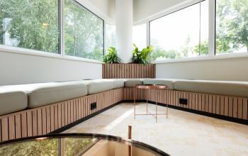 Bright corner lounge area with large windows and comfortable seating at Overschiestraat 65 office space rental in Amsterdam New-West.