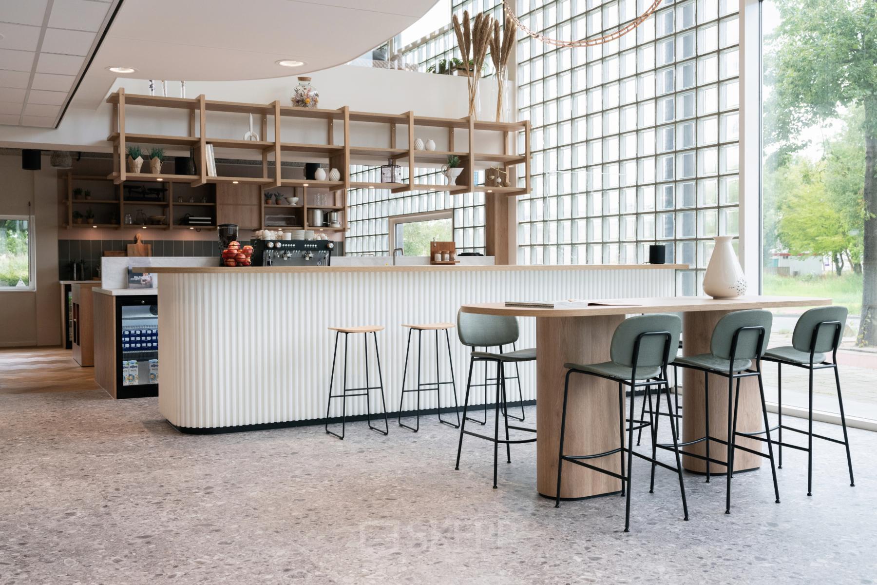Modern office space rental at Overschiestraat 65, Amsterdam Nieuw-West, featuring a stylish pantry with seating area.