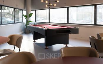 Modern lounge area with a pool table and seating at the office space rental on Overschiestraat 63, Amsterdam New-West.