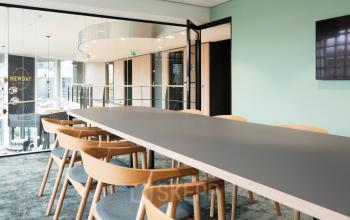 Spacious conference room with a large table and wooden chairs at Overschiestraat 63 in Amsterdam New-West, available for office space rental.