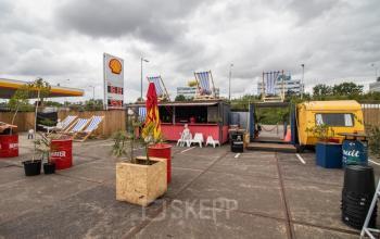 Outdoor area at Anthony Fokkerweg 3, in Amsterdam Nieuw-West, featuring colorful seating arrangements next to a shipping container, suitable for creative workspace solutions with potential for office space rental.