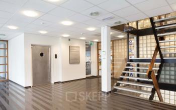 Spacious entrance area of an office building located at Baden Powellweg 283/305, Amsterdam New-West, featuring clean lines and modern amenities. Ideal for office space rental.