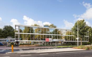 Modern office building at Baden Powellweg 283/305 in Amsterdam Nieuw-West featuring large glass windows and surrounded by greenery.
