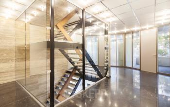 Modern office space in Amsterdam New-West with glass-enclosed staircase and bright lighting, located at Baden Powellweg 283/305.