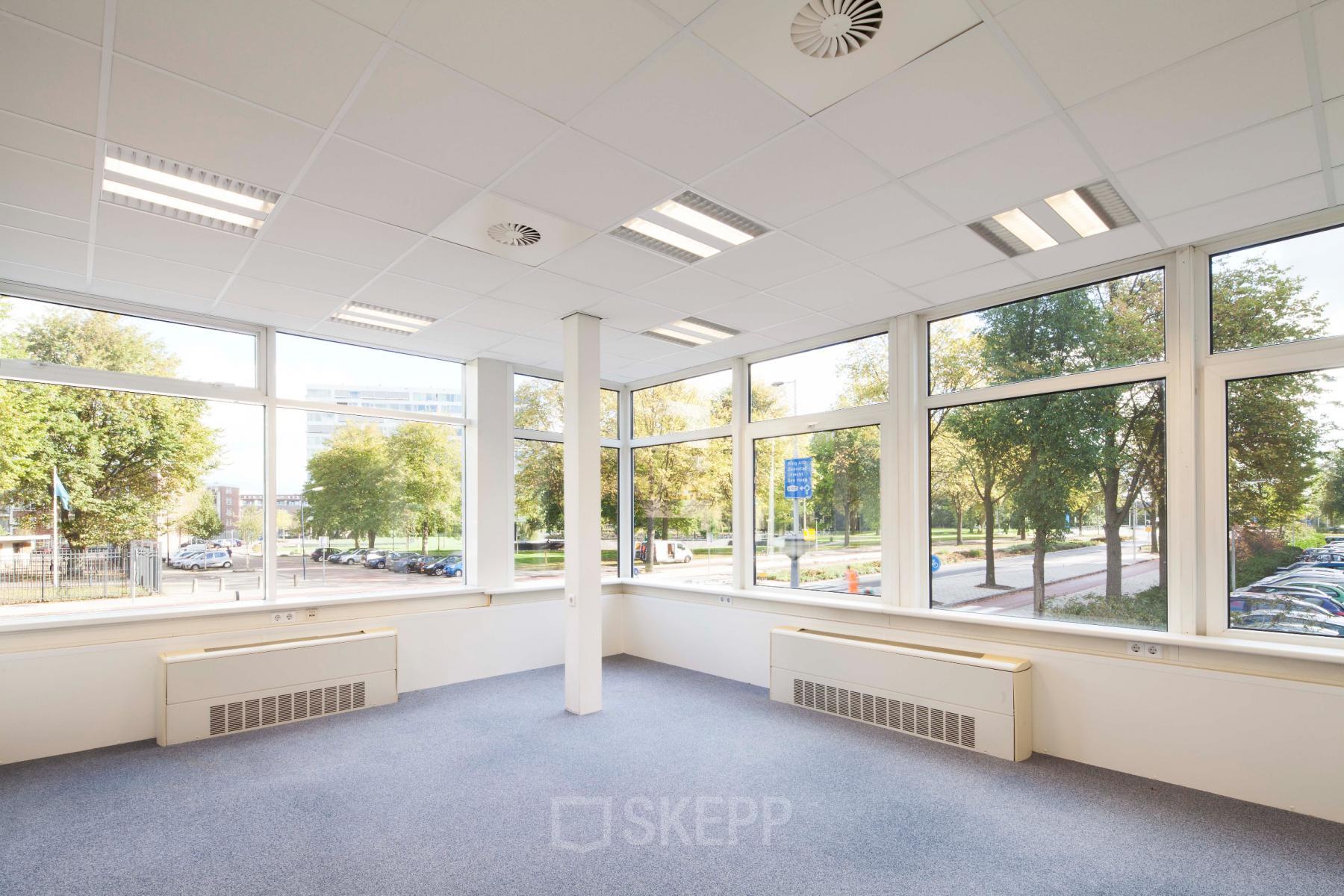 Bright, spacious office area with large windows at Baden Powellweg 283/305, Amsterdam New-West, available for office space rental, offering plenty of natural light and green views.