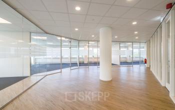 Modern office space at Overschiestraat 61, Amsterdam New-West, with glass partitions and wooden flooring, suitable for office space rental.