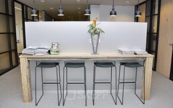 nice high table with four chairs and some flowers