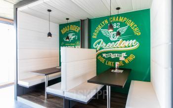 Youthful office space with booth seating and vibrant wall art for rent at Kraanspoor 12-58, Amsterdam North.