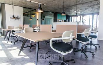Bright office space for rent in Amsterdam North at Kraanspoor 12-58 with modern furnishings, open floorplan, and ample natural light from large windows.