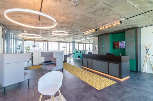 Modern office space for rent at Kraanspoor 12-58, Amsterdam North, featuring contemporary lighting, seating areas, and a reception desk, ideal for office space rental.
