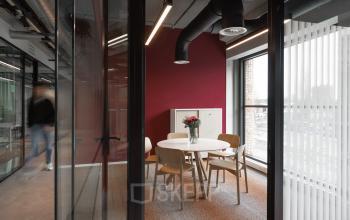 Cozy office space in Amsterdam North with a round table and chairs, ideal for meetings. Rent office space at Papaverhof 58 for a modern workspace vibe.