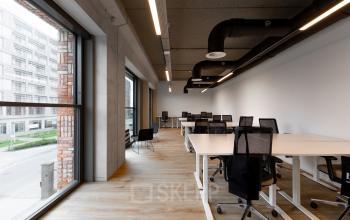 Spacious office to rent in Amsterdam North featuring large windows, modern furniture, and ample desk space, ideal for collaborative work. Perfect office space rental opportunity in Papaverhof 58.