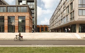 Exterior view of office buildings at Papaverhof 58, Amsterdam North, with people walking and cycling, ideal for office space rental.