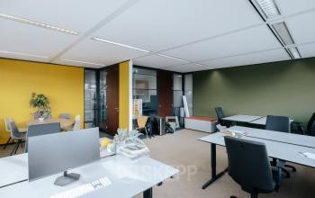 Bright and furnished office space at TT Vasumweg 44 in Amsterdam North, featuring tables, chairs, and a computer, ideal for those looking to rent office space.