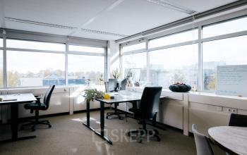 A bright, furnished office space with large windows and several desks available for rent at TT Vasumweg 44, Amsterdam North.