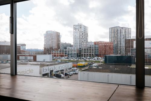 View from an office space rental at TT Vasumweg 44, Amsterdam North, showcasing the surrounding buildings through a large window.
