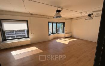 Open and well-lit office space at Hamerstraat 24, Amsterdam North, with large windows and hardwood floors.