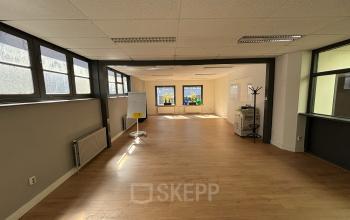 Spacious office to rent at Hamerstraat 24, Amsterdam North, featuring large windows, wooden floors, and ample natural light.