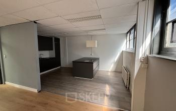 Interior of an office space at Hamerstraat 24 in Amsterdam North with modern kitchenette, island, large windows, and natural light. Suitable for office space rental.