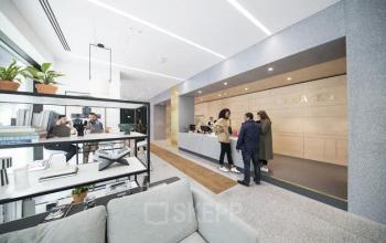 Modern office reception area with a sleek design at Mt. Lincolnweg 38-40, Amsterdam North, featuring contemporary furnishings and people engaged in business conversation. Ideal for office space rental seekers.