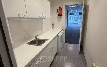 Compact office pantry with white cabinetry and sink, located at Buikslotermeerplein 430, Amsterdam North, perfect for small office space rental.