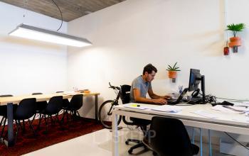 Modern office space rental at Asterweg 19, Servicepunt Kaap Noord, Amsterdam North, with a person working at a white desk with a computer