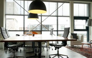 Well-appointed office space rental at Asterweg 19, Amsterdam North, with a large table, chairs, and stylish overhead lighting.
