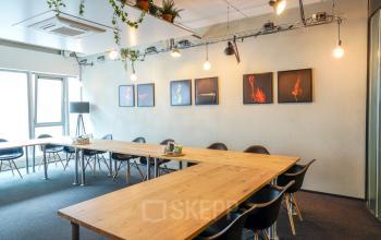 Modern conference room available for office space rental at Asterweg 19, Amsterdam North, with a large wooden table and stylish décor.