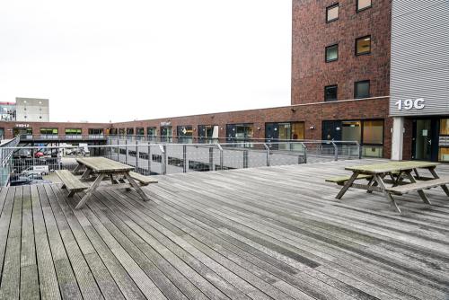 Asterweg 19 Amsterdam North offers an inviting terrace as part of its office space rental, showcasing outdoor benches and a modern building facade.