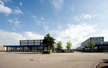 Exterior of the office buildings located at Distelweg 78-80 in Amsterdam North, Amsterdam, featuring a modern design and ample parking space.