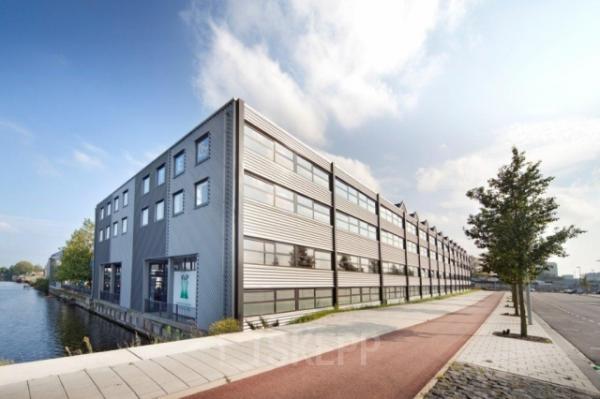 Exterior view of office building at Distelweg 78-80, Amsterdam North, showcasing modern architecture by the canal available for office space rental.