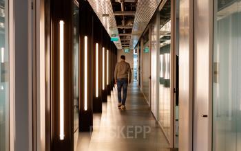 Interior hallway at Science Park 301, Amsterdam East, with modern lighting and a person walking, offering an ideal location for office space rental.