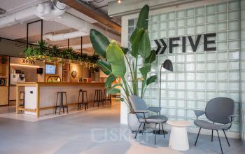 Modern office interior with a stylish lounge area, featuring plant decor and comfortable seating, located at Science Park 301 in Amsterdam East. Ideal for office space rental.