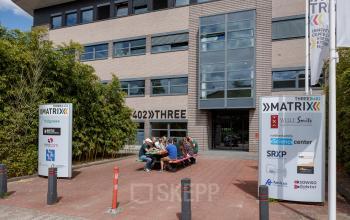 Exterior view of office building at Science Park 301, Amsterdam East, showing modern architecture with business signage. Office space rental available in a vibrant setting.