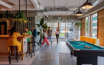 Modern office space at Science Park 301 in Amsterdam East with a lively lounge area featuring a pool table and seating for collaboration. Ideal for office space rental enthusiasts.