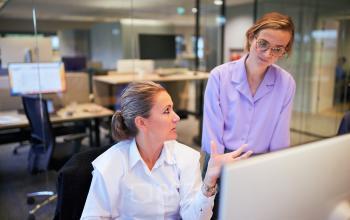 Modern office setting at Science Park 301 in Amsterdam East, featuring professionals engaged in discussion, ideal for office space rental.