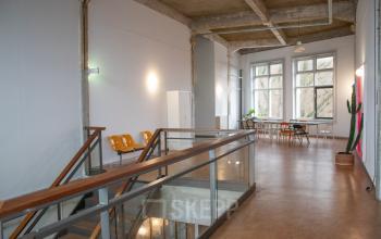 Interior view of a modern office with seating area, large windows, and potted plants at KNSM-Laan 171, perfect for office space rental in Amsterdam East.