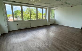 Unfurnished office space with large windows overlooking a green view at James Wattstraat 71, offering bright natural light, ideal for rent office space in Amsterdam East.