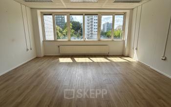 Unfurnished office to rent at James Wattstraat 71, Amsterdam East, with large windows offering natural light and a view of the surrounding area.