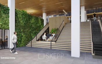 Modern entrance lobby at Jacob Bontiusplaats 9, Amsterdam East, featuring a green wall, seating area, and people engaged in business discussions.